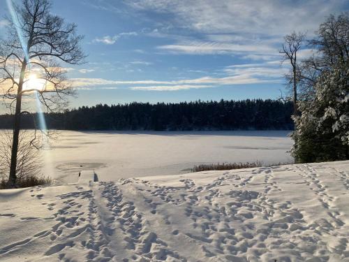 a snow covered field with a large body of water at Leśniczówka Szeroki Bór in Szeroki Bór