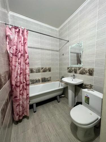 a bathroom with a toilet and a tub and a sink at Гостиница NUR in Aralʼsk