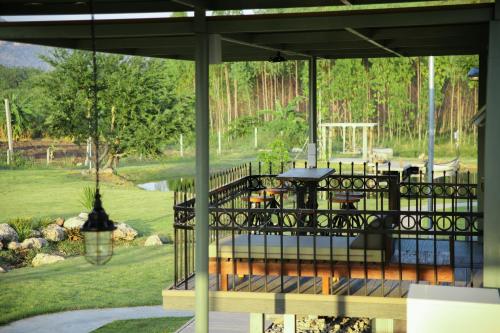 a screened in porch with a view of a garden at Nex Station Kanchanaburi in Kanchanaburi