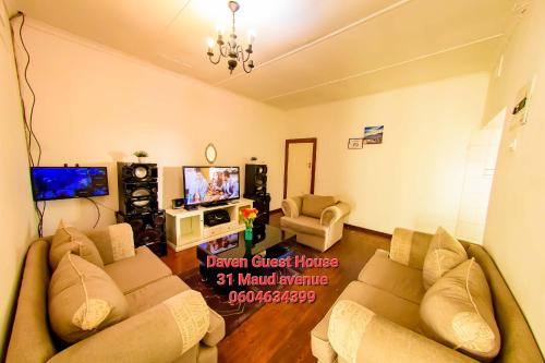 a living room with two couches and a tv at Daven Guest House (DGH) in Pietermaritzburg