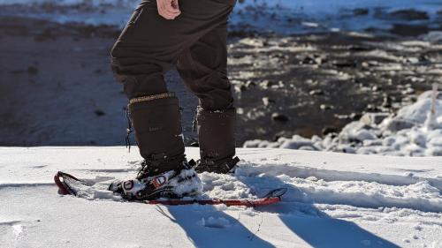 una persona parada en un par de esquís en la nieve en La Gentilhommière Motel et Suites B Vue sur Mer en Saint-Siméon