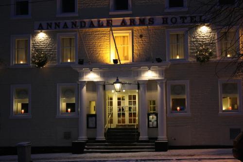 a building with the entrance to an amazon noir arms hotel at night at Annandale Arms Hotel in Moffat