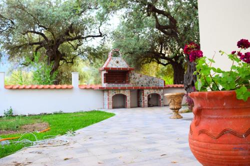 a garden with a house and a vase with flowers at Tsafas Αpartments in Limenas