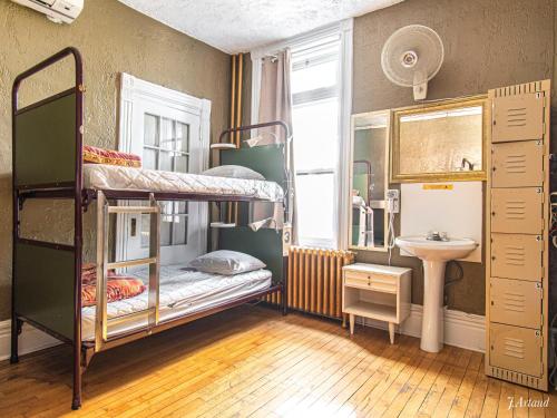 Cette chambre comprend 2 lits superposés et un lavabo. dans l'établissement Auberge du Plateau, à Montréal
