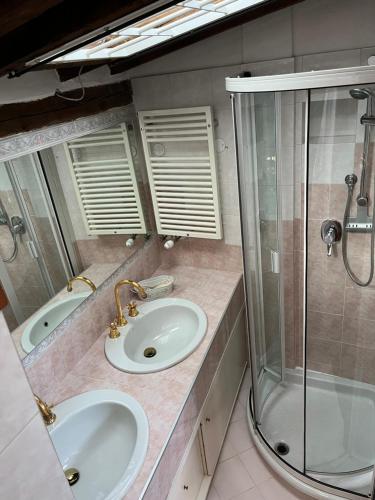 a bathroom with two sinks and a shower at Loft Albinelli Wi-Fi e parcheggio gratis in centro in Modena
