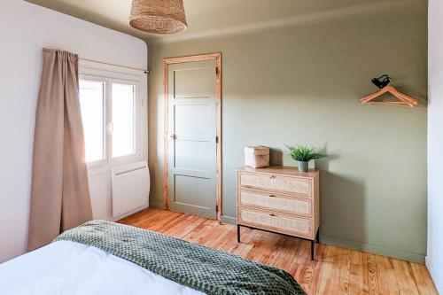 a bedroom with a bed and a dresser and a window at Maison Lombardi - Gite 6 Personnes 4 étoiles in Dun-sur-Meuse