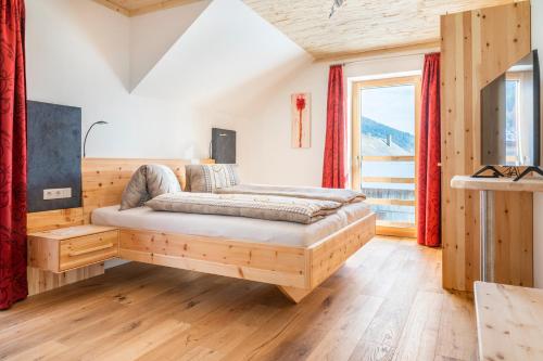 ein Schlafzimmer mit einem Bett und einem großen Fenster in der Unterkunft Moamoosgut in Göriach