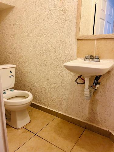 a bathroom with a toilet and a sink at Casa a 7 min de playa in Ixtapa