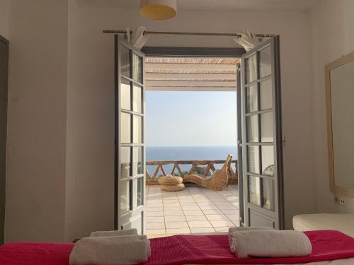 Habitación con puerta abierta y vistas al océano en Melina's House, en Koundouros