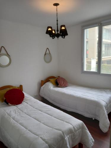 1 dormitorio con 2 camas y un hombre durmiendo en ellas en Playa 2 en Mar del Plata