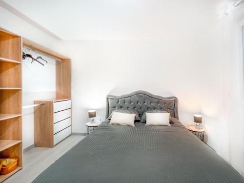 1 dormitorio con 1 cama gris grande y 2 almohadas en La coulée verte, en Auxerre