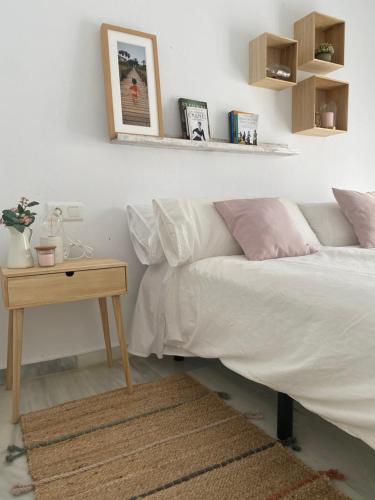 a bedroom with a bed and a nightstand with a table at Casa Pandora Apartamento Duplex Atico, primera línea de playa Torrox in Torrox Costa