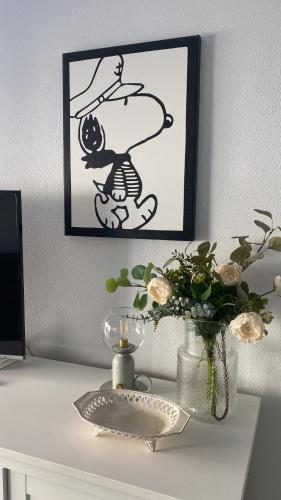 a table with a vase of flowers and a picture at Casa Pandora Apartamento Duplex Atico, primera línea de playa Torrox in Torrox Costa