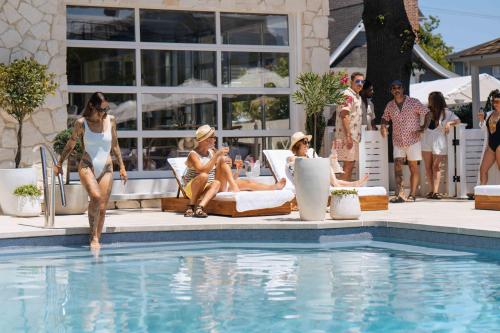 um grupo de mulheres sentadas em torno de uma piscina em The St Laurent Guest Rooms em Asbury Park
