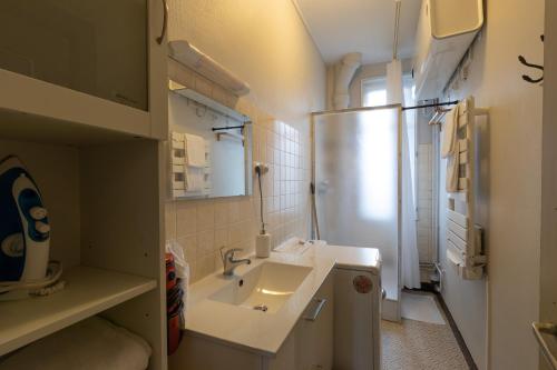 a small bathroom with a sink and a refrigerator at CABANA & Confort - Proche Centre-Ville , Parking in Tournus