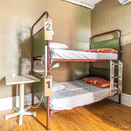 two bunk beds in a room with two signs at Auberge du Plateau in Montréal