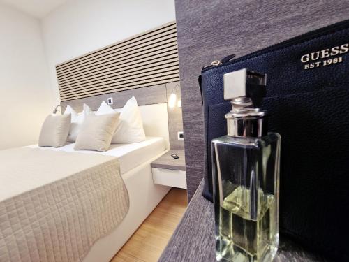 una botella de perfume sentada en una mesa en una habitación de hotel en Residence-Apartment-Giuliano-Punta Skala, en Petrcane