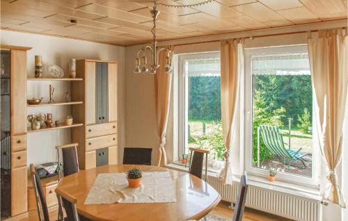 ein Esszimmer mit einem Tisch und einem großen Fenster in der Unterkunft Ferienhaus Hennebacher Str. S in Bad Brambach