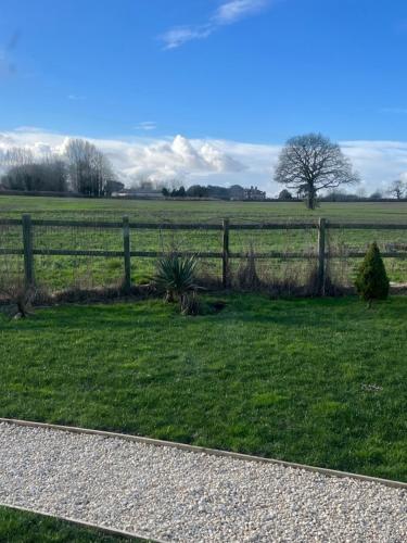 a fence in the middle of a grass field at Rife Lodges in Arundel