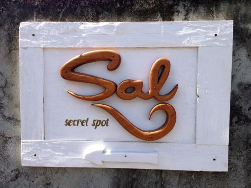 a white sign with a pretzel on it at Sal Secret Spot in Uluwatu