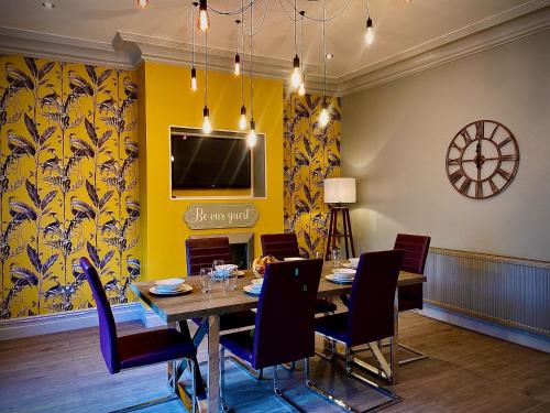 a dining room with a table and chairs and a clock at Captivating 4-Bed Hot Tub House in Blackpool in Blackpool