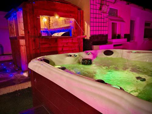 a bathroom with a tub with green and pink lighting at Captivating 4-Bed Hot Tub House in Blackpool in Blackpool