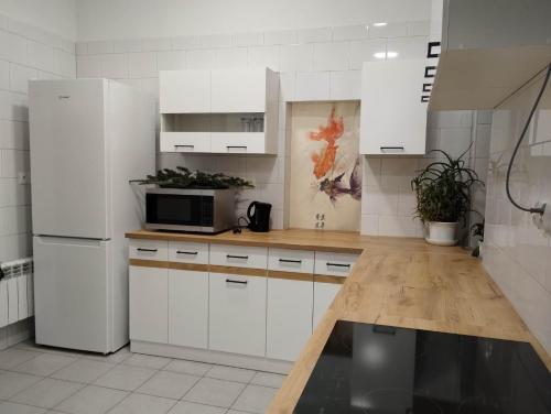 a kitchen with white cabinets and a white refrigerator at Willa 桃 MoMo Szczawnica in Szczawnica