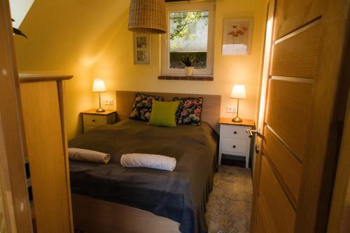 1 dormitorio pequeño con 1 cama y 2 lámparas en V4 Kilátóterasz Apartmanok Emelet, en Nagymaros