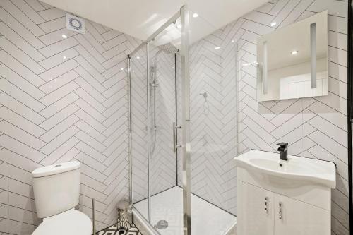 e bagno con doccia, servizi igienici e lavandino. di Elegant Yorkshire Abode - Great Location - Sleeps 19 a Castleford