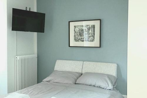 una camera con un letto e una foto appesa al muro di Grazioso appartamento in centro storico a Trento