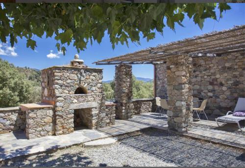 ein Steingebäude mit einem Kamin im Hof in der Unterkunft Le MONTE-CINTO -LOCATION EN PIERRE ENTRE MER ET MONTAGNE in Moltifao