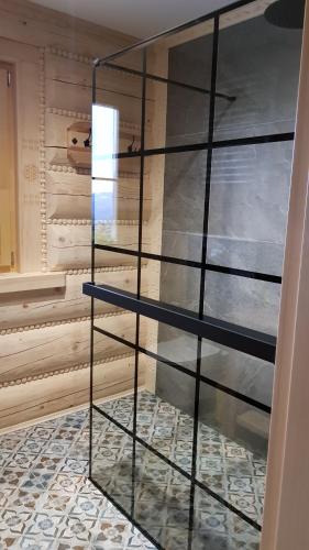 una parete in vetro in una stanza con pavimento piastrellato di Górskie Przysiółki w Koniakowie - Dom z bala GÓRALSKI LOFT a Koniaków