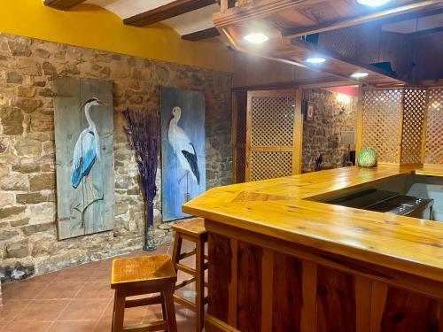 a kitchen with two paintings of birds on the wall at Casa Rural La Yedra in Galve