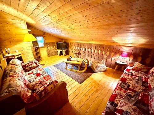 Cabaña con sala de estar con sofá y TV. en Refuge des Cimes, en Saint-Laurent-en-Grandvaux