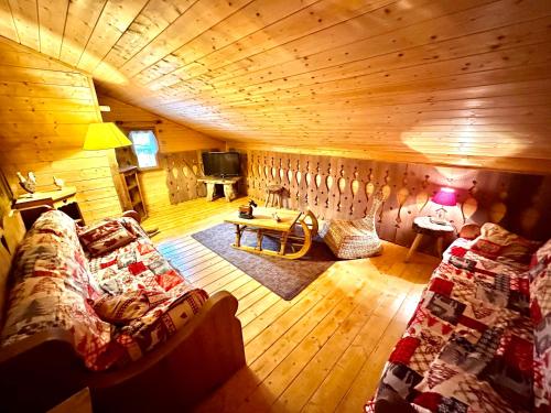 a living room with a couch and a tv in a cabin at Refuge des Cimes in Saint-Laurent-en-Grandvaux