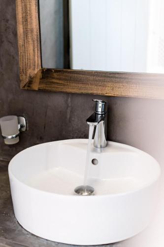 a white sink in a bathroom with a mirror at Aspa Caves in Oia