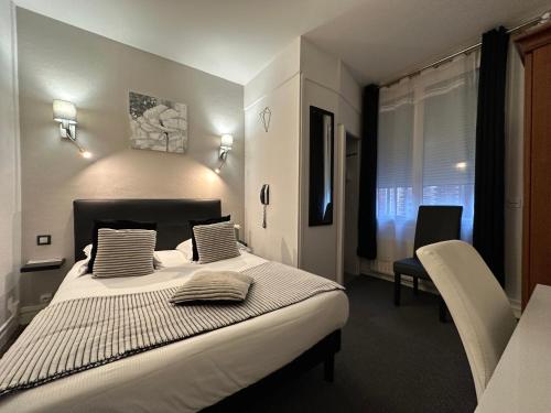 a bedroom with a large white bed with two pillows at Hotel Le Saint-Yves in Le Tréport