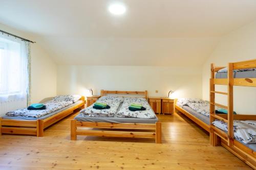 a bedroom with three bunk beds and wooden floors at Apartmány Petra in Hřensko