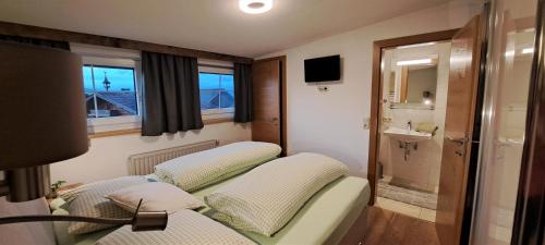 ザールフェルデン・アム・シュタイナーネン・メアーにあるUnterlettlhofのベッド2台とシンクが備わる小さな客室です。
