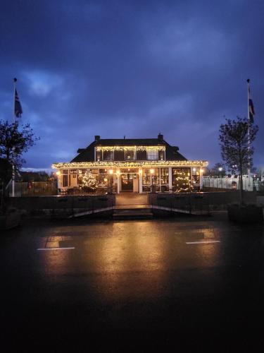 a building lit up at night with lights on it at Café Brasserie Het Heerenhuis in Het Kalf