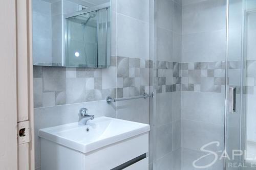 a white bathroom with a sink and a shower at Saplan Real Estate PENSAUETH in Salardú