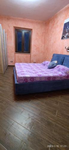 a bedroom with a large bed with a purple blanket at CASA ALICE in Poggio Catino