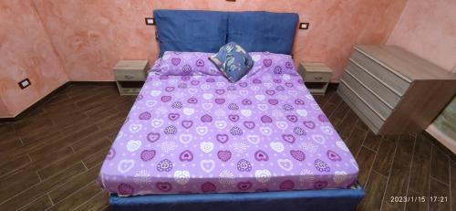 a bed in a room with a purple bedspread at CASA ALICE in Poggio Catino