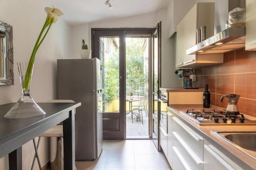 a kitchen with a stainless steel refrigerator and a table at Life is Beautiful Design LOFT Navigli Romolo, SmartTV, WiFi, AC and street parking in Milan