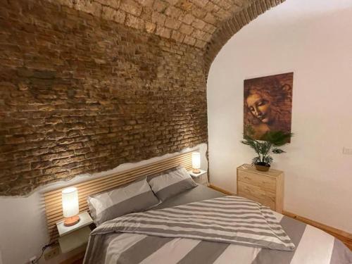 Un dormitorio con una pared de ladrillo y una cama en CASA ANTICA - antique apartment with private terrace, en Roma