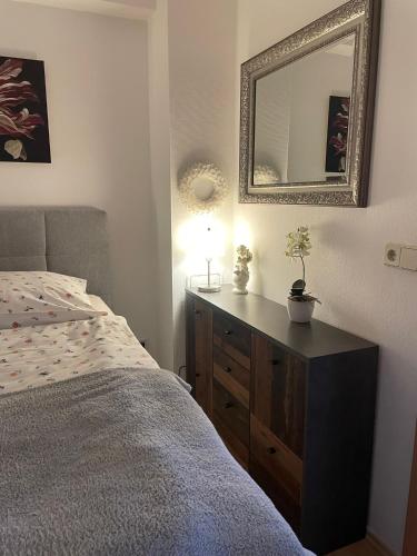 a bedroom with a bed and a dresser with a mirror at Ferienwohnung Landidylle in Gieckau