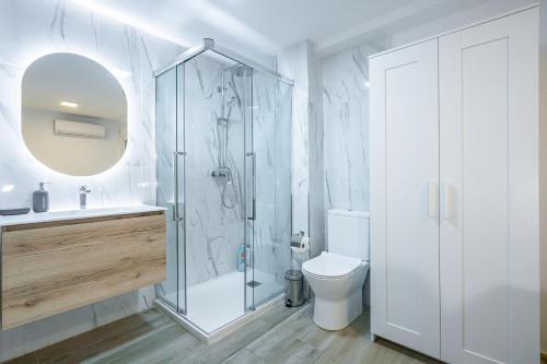 a bathroom with a shower and a toilet and a sink at Sunny rooms on Cabañal beach in Valencia