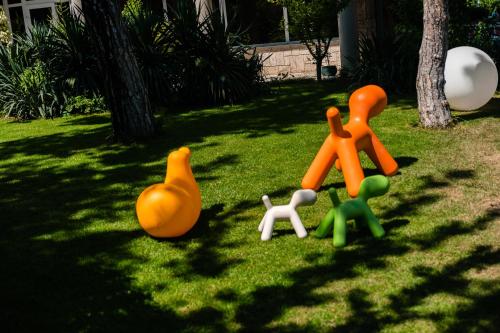 a group of plastic toy people on the grass at Hotel Carmen in Eforie Nord