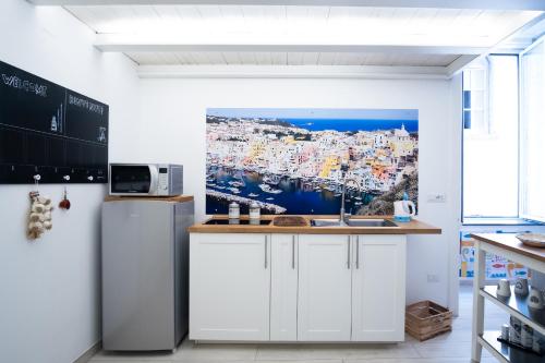 een keuken met witte kasten en een schilderij aan de muur bij Mare Napoli in Napels