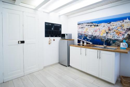 een keuken met witte kasten en een schilderij aan de muur bij Mare Napoli in Napels